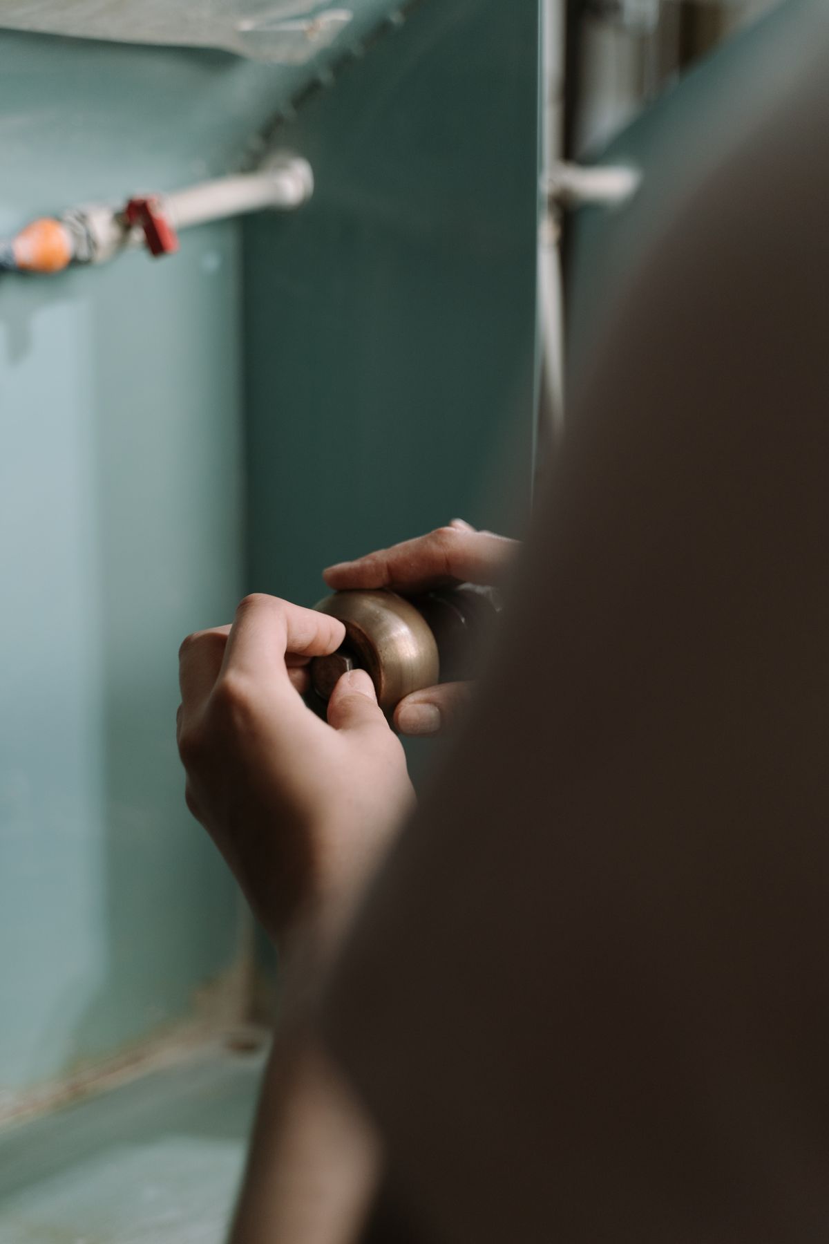 A plumber clearing a drain line under a sink